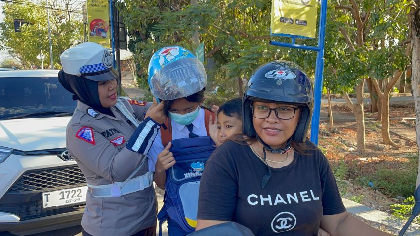 Polwan Polda NTT Bagikan Bunga dan Helm ke Warga