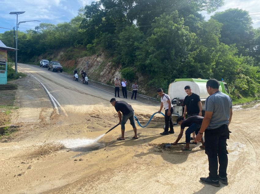 Polisi Bersihkan Material Lumpur dan Tanah di Pertigaan Wae Cicu